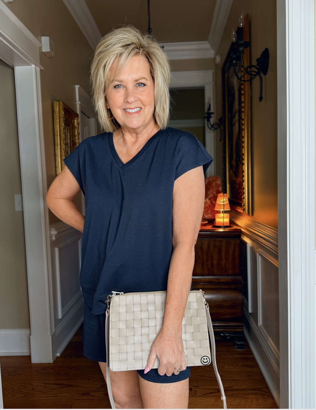 Tania Stephens wearing a  navy blue matching short set with a envelope clutch from Quince